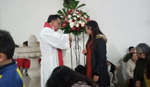 Dando la Comunión durante Confirmación de jóvenes